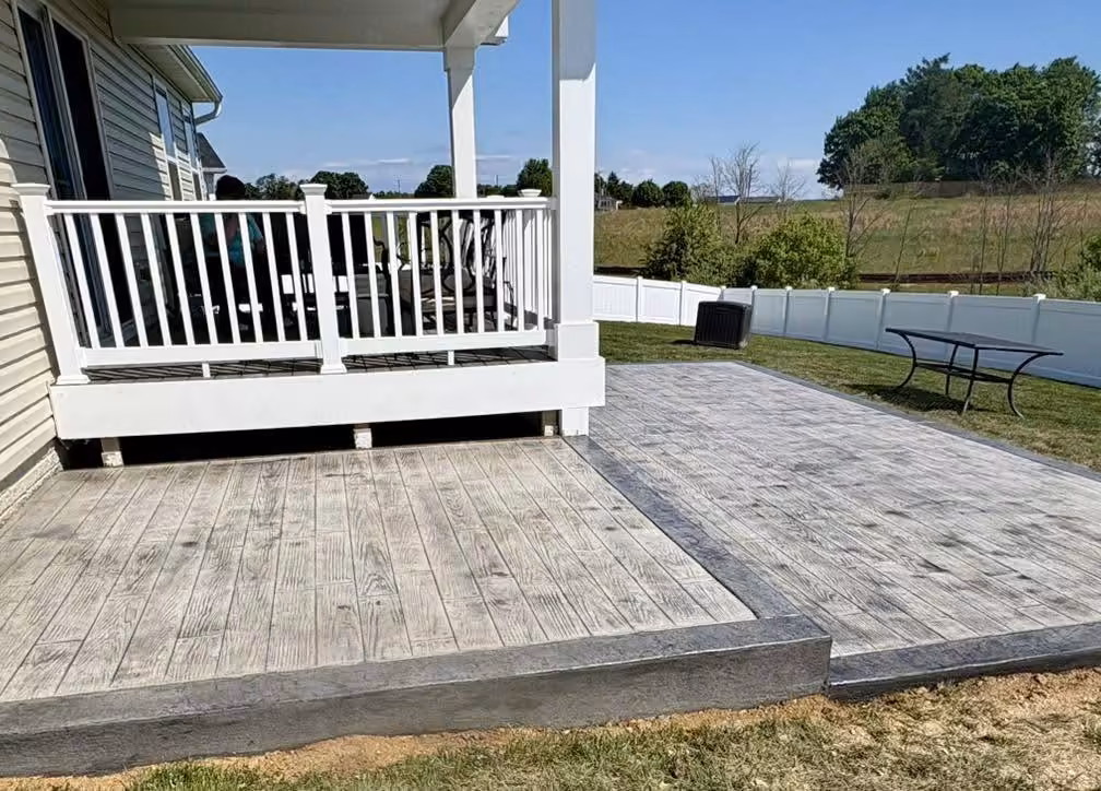 Two-level wood plank stamped concrete patio stepping down from a covered porch